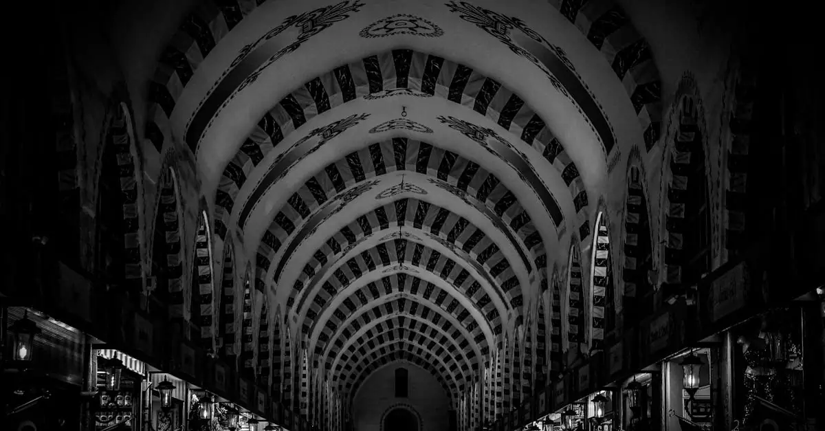 A dramatic black and white capture of the ornate ceilings and bustling atmosphere inside Istanbul's historic Grand Bazaar.