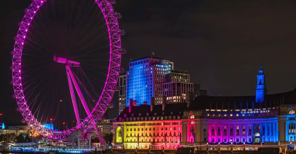 Stunning nighttime view of the illuminated London Eye reflecting on the River Thames.