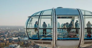 Tourists enjoying scenic views from the London Eye capsule in daylight.