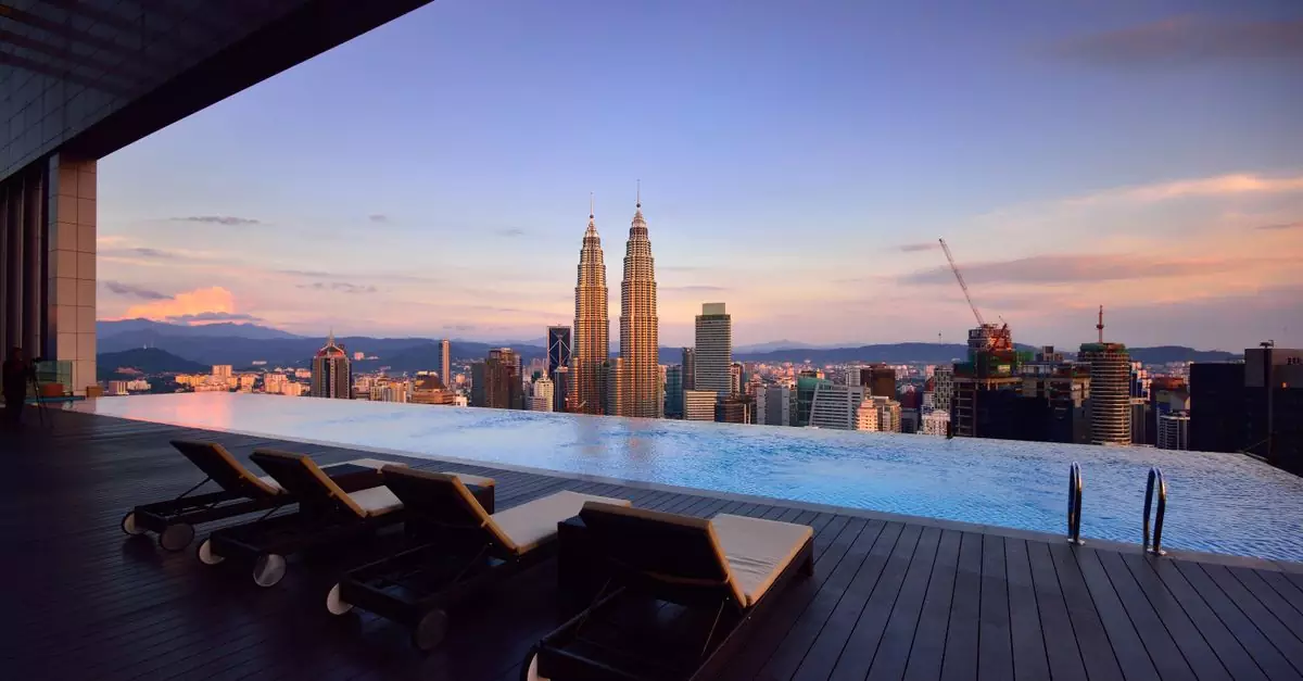 Relax by a luxury infinity pool with stunning Kuala Lumpur skyline and Petronas Towers at twilight.