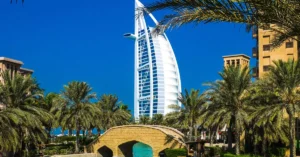 Scenic view of Burj Al Arab surrounded by lush palm trees and clear blue sky in Dubai.