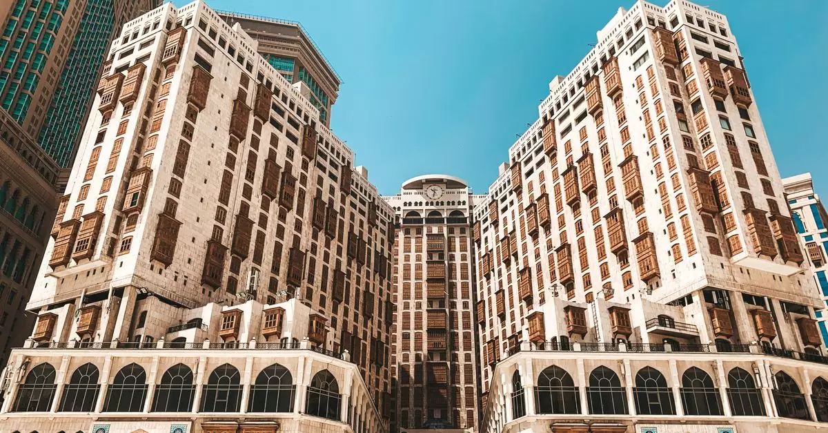 Low angle view of a modern hotel in Makkah under a clear blue sky.
