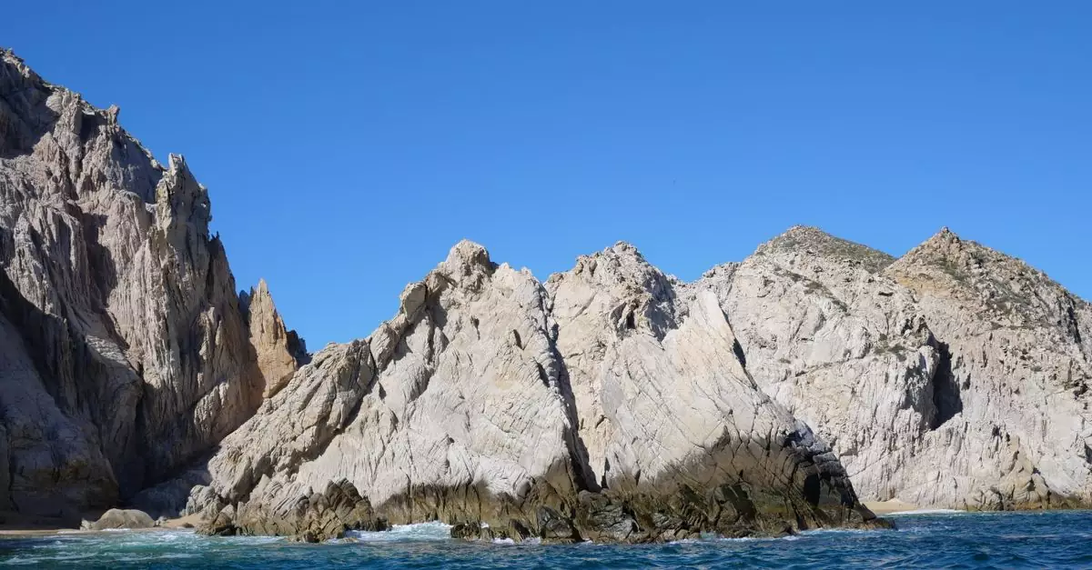 Breathtaking view of rocky sea cliffs against a clear blue sky at Cabo San Lucas, Mexico.