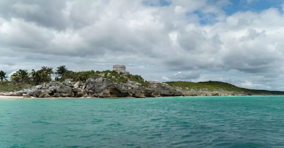 Beautiful turquoise waters and rocky shores surrounding the Tulum ruins. Ideal for travel and nature enthusiasts.