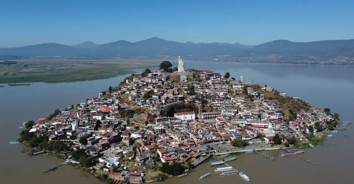 Aerial view of Janitzio Island with its iconic statue and surrounding landscape.