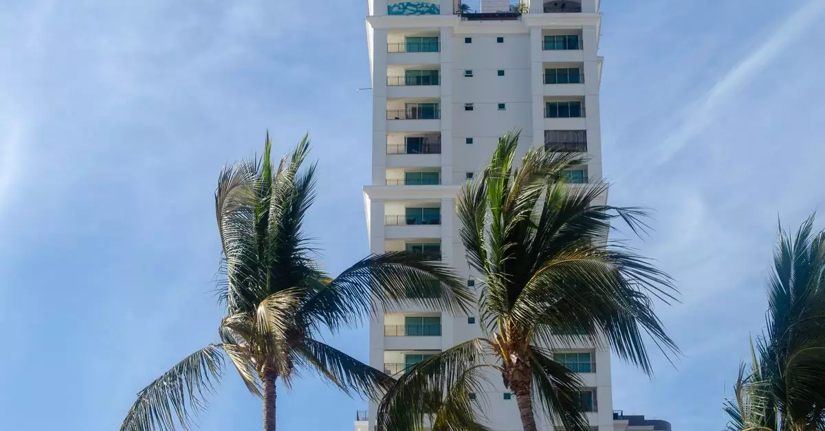Tall hotel building with palm trees under a clear blue sky in Puerto Vallarta, Mexico.