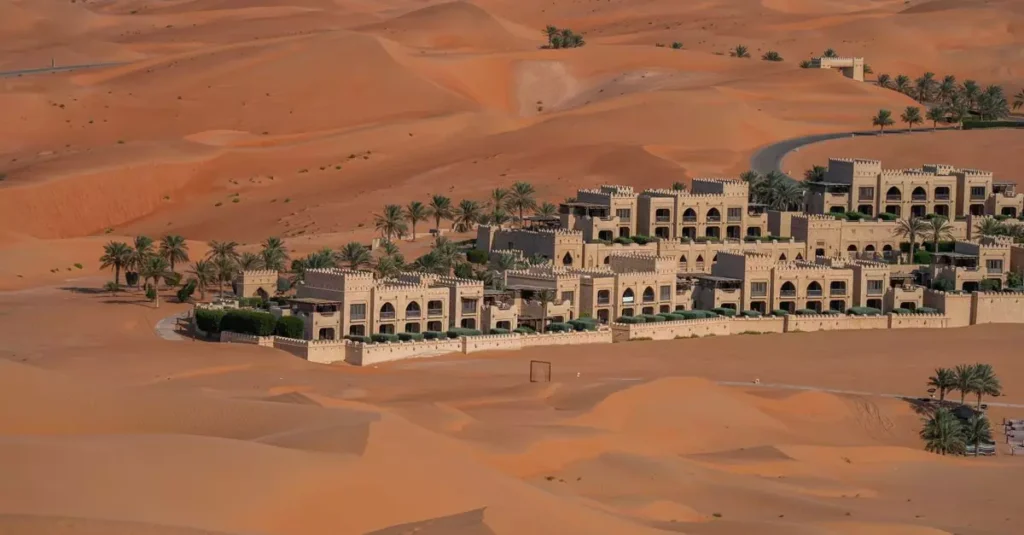 Best Middle East Adventure Resorts for Thrilling Getaways 3 Explore the vast desert landscape of Abu Dhabi with this aerial view showcasing a luxurious hotel surrounded by sand dunes.