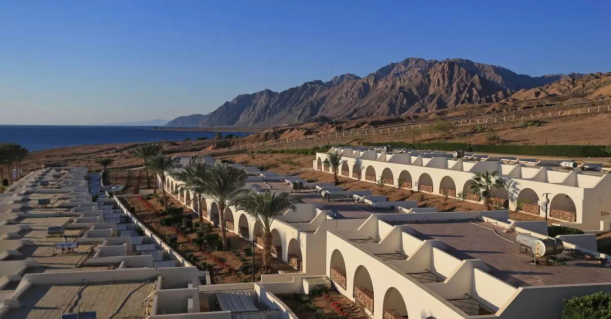 Aerial view capturing the elegant architecture along the coastal line of Dahab, Egypt with mountains in the backdrop.