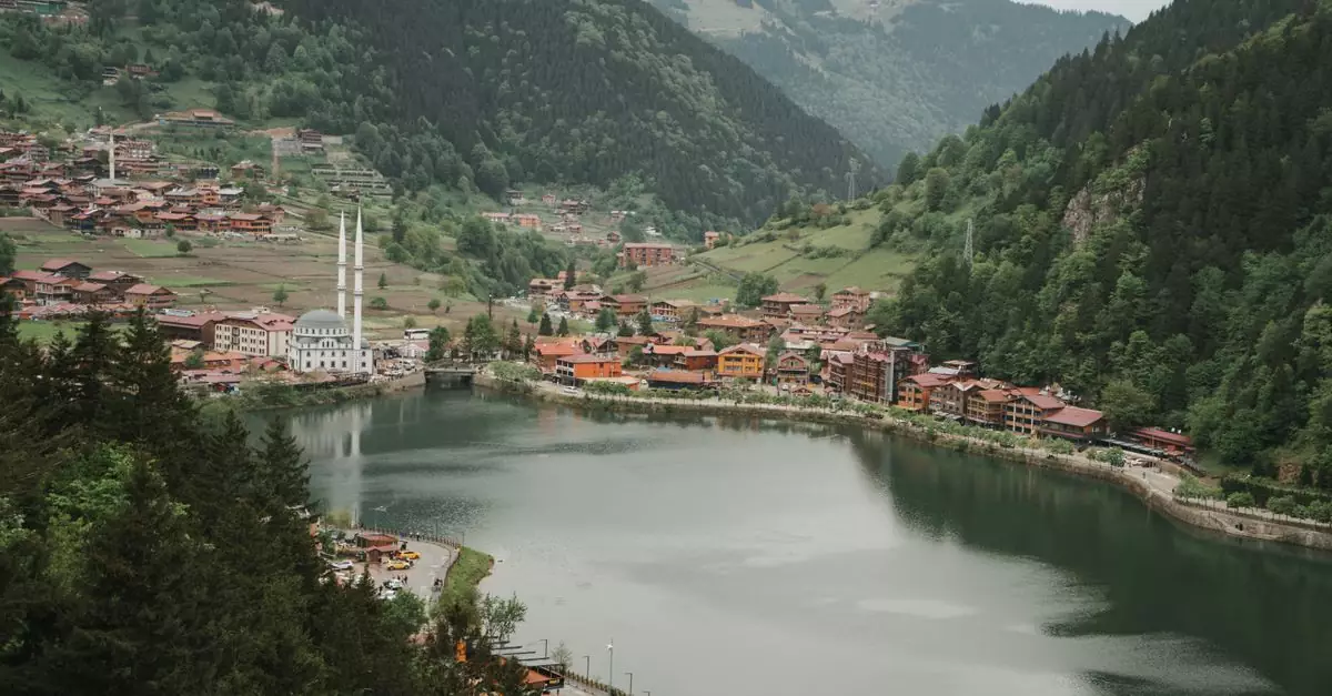 A breathtaking aerial view of Uzung&ouml;l Lake surrounded by lush green mountains and traditional architecture in Turkey.