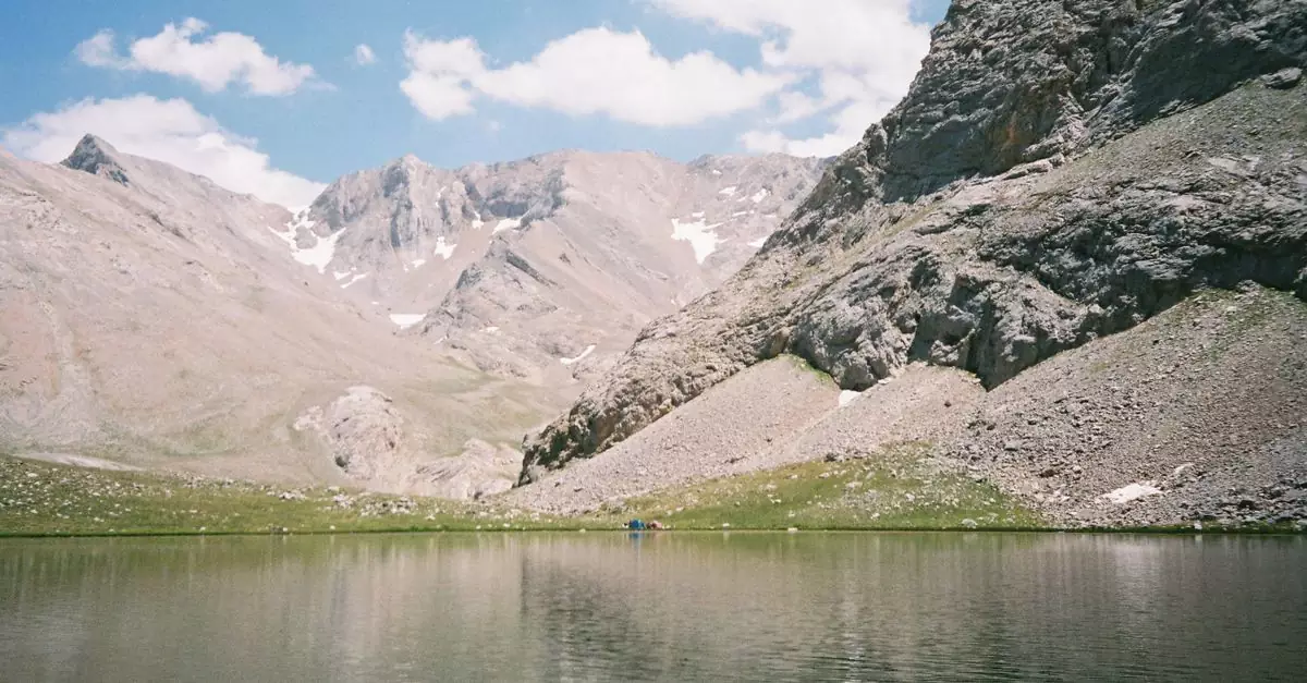 Peaceful mountain lake in Adana, T&uuml;rkiye with clear sky and reflective water surface.