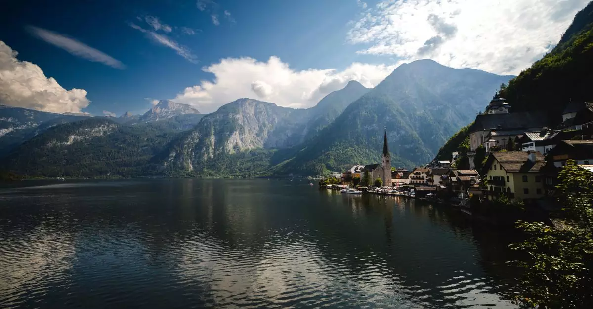 Scenic view of Hallstatt by the lake with towering Alps in the background, showcasing natural beauty.