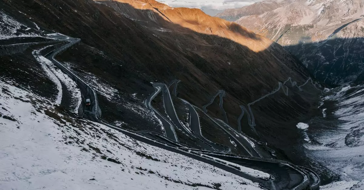 Scenic winter view of Stelvio Pass winding through snow-covered mountains in the Italian Alps.
