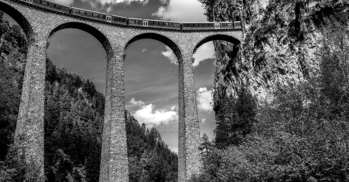 Black and white image of a train crossing the iconic Landwasser Viaduct in Switzerland.