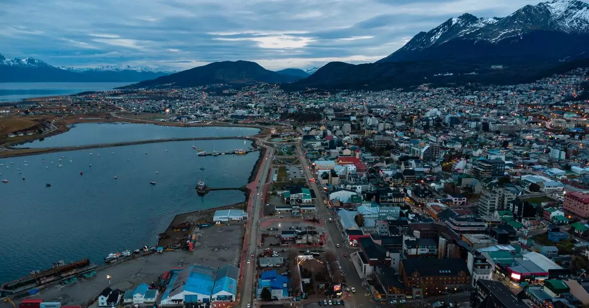 Stunning aerial view of Ushuaia, Argentina, with mountains and harbor at twilight.