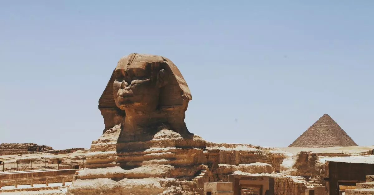 View of the Great Sphinx of Giza and Pyramid, iconic Egyptian landmarks in daylight.