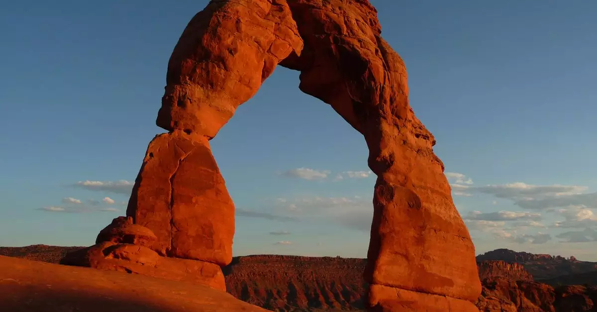 Capture of the iconic Delicate Arch in Utah's Arches National Park during sunset showcasing its stunning red hues.