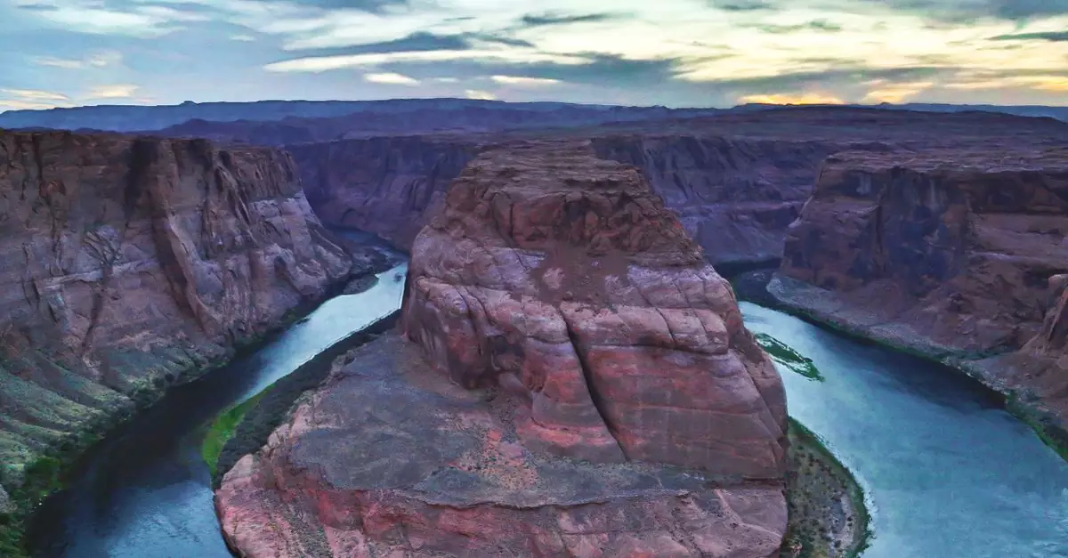Stunning aerial capture of Horseshoe Bend, Arizona at sunset with vibrant sky and river curve.