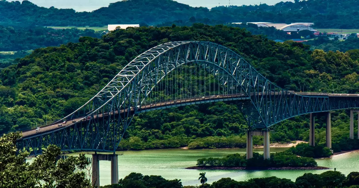 A scenic view of the Puente de las Americas spanning over Panama's lush forests and water.