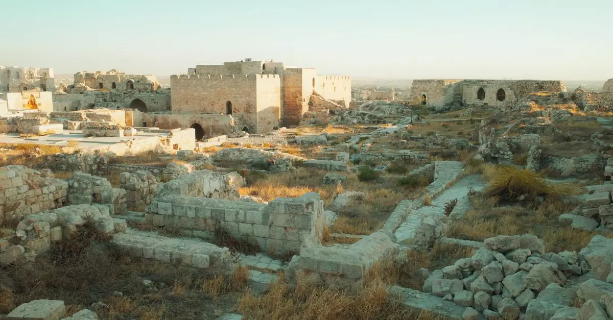 Explore the historic Aleppo Citadel ruins in Syria at sunrise, showcasing ancient architecture.