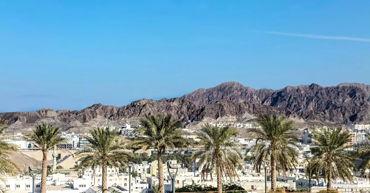 Desert mountains and palm trees under a vibrant blue sky.