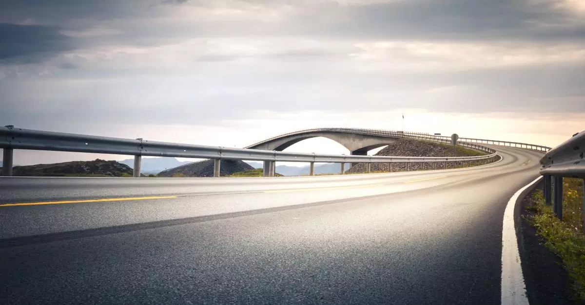 Captivating view of Atlantic Ocean Road, Norway, under a dramatic sky at sunset.