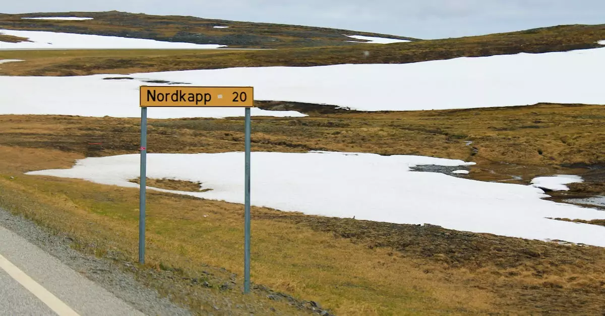 Roadside view near Nordkapp, Norway with snowy patches and mountain scenery.