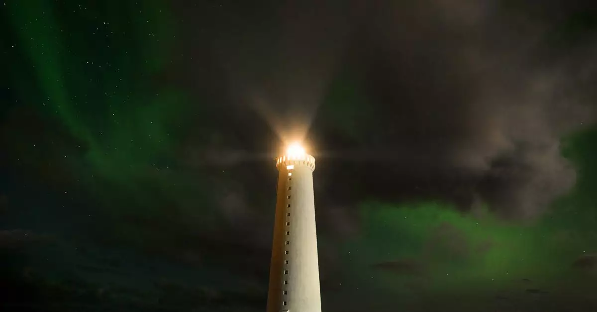 From below lighthouse tower located on coast glowing and signaling for ship at dark night