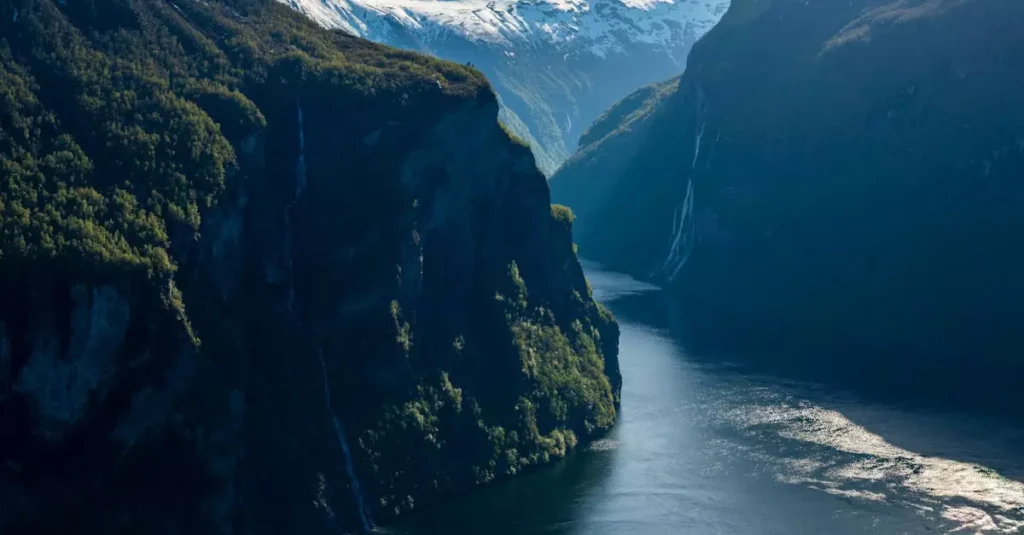 Best Norway Fjords: Your 2026 Travel Guide 12 Breathtaking view of Geiranger Fjord, Norway, with snow-capped mountains and serene blue waters.