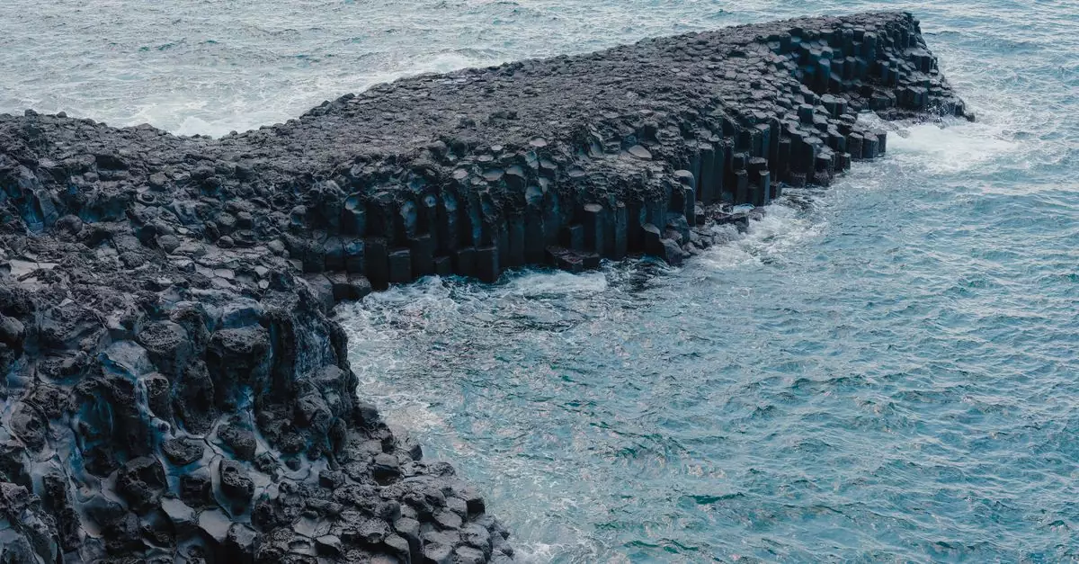 Stunning view of basalt columns meeting the ocean at Seogwipo-si, Jeju, Korea.