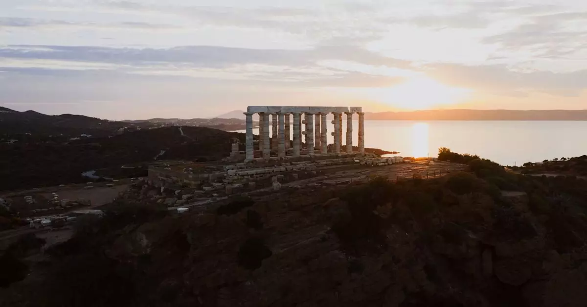 Stunning sunset at the Temple of Poseidon in Sounion, Greece with serene sea views.