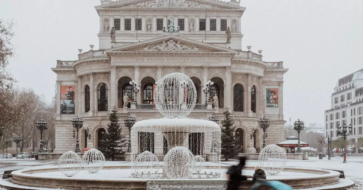 A winter view of the Alte Oper in Frankfurt with snow and illuminated fountains.