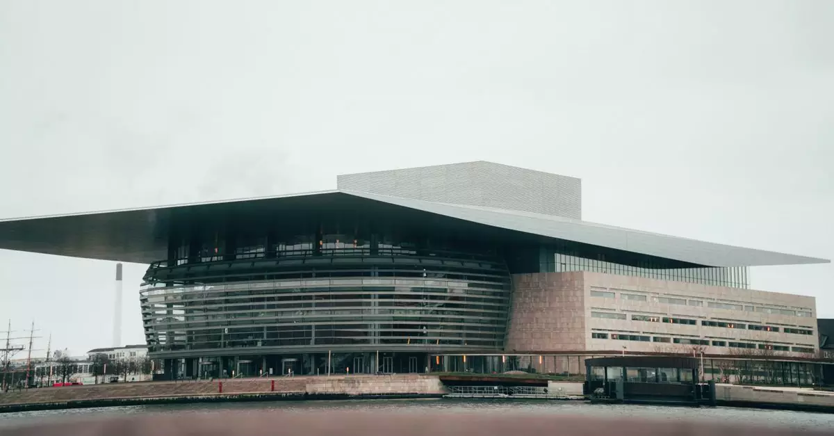 A modern architectural marvel, the Copenhagen Opera House stands impressive against the cloudy sky.