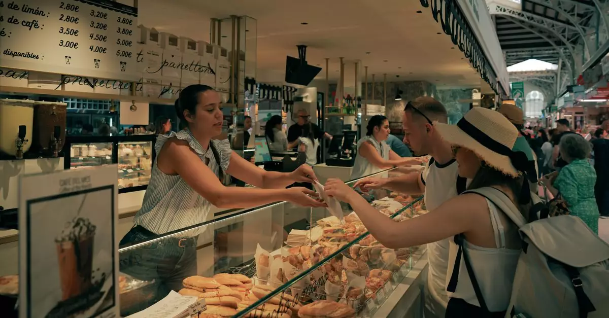 Customers buying pastries in Valencia's bustling Central Market, Spain.