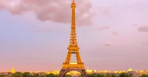 Capture of the Eiffel Tower in Paris at dusk with a vibrant sky, showcasing its iconic structure.