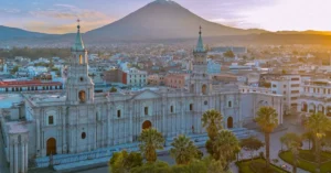 Drone shot of Arequipa's cathedral with El Misti volcano in the background at sunset.