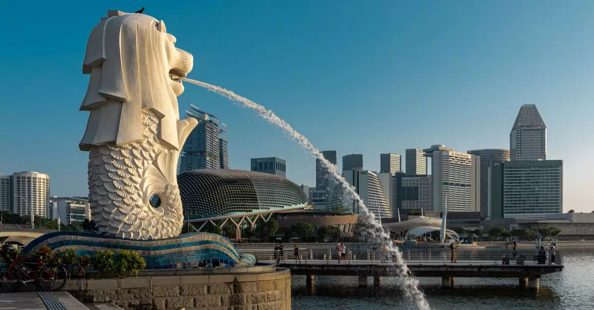 Iconic Merlion statue with Singapore skyline under clear blue sky, showcasing modern architecture and city's charm.