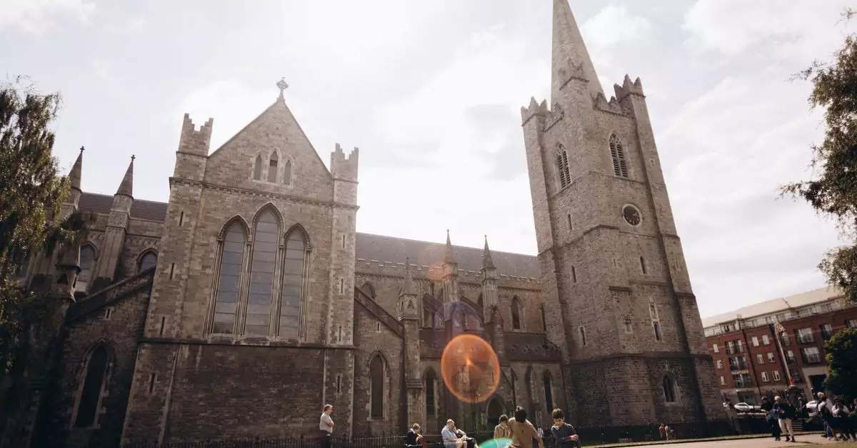 Stunning view of Saint Patrick's Cathedral with people enjoying a sunny day in Dublin, Ireland.