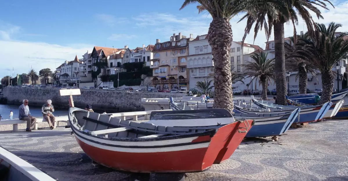 Charming coastal scene with colorful boats and palm trees in Cascais, Lisbon.