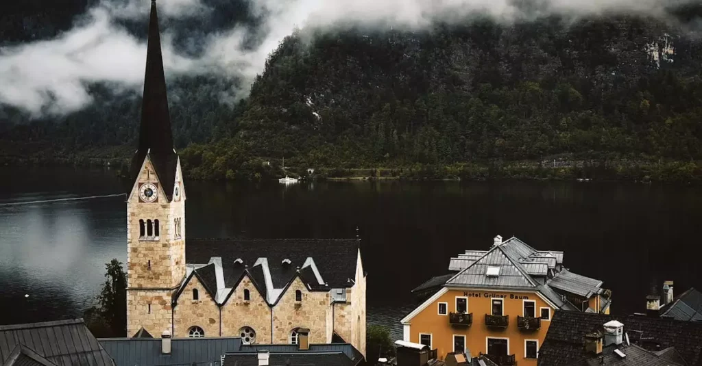 Best Quiet Destinations in Europe: Peaceful Escapes 2 A picturesque scene of Hallstatt village with misty mountains and a lakeside view.