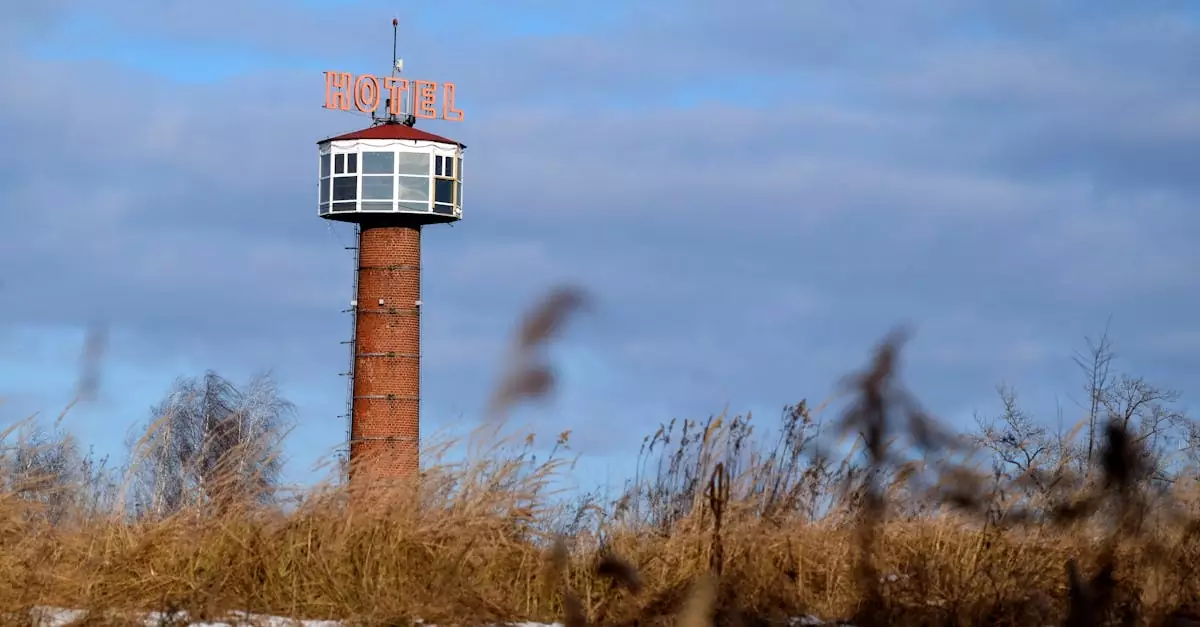 A unique hotel observation tower stands isolated amidst a grassy field.