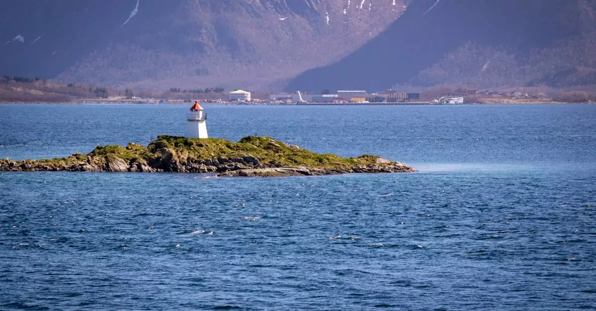 A picturesque lighthouse on a small Norwegian islet surrounded by mountain views and a seascape.