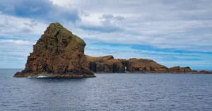 Stunning rock formations in the Azores, Portugal under a dramatic sky over the Atlantic Ocean.