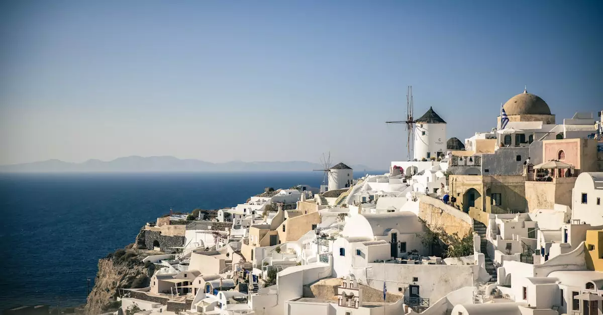 Beautiful view of Santorini's iconic white buildings and blue sea under a clear sky.
