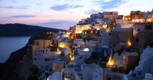 Beautiful illuminated cityscape of Santorini at dusk overlooking the Aegean Sea.