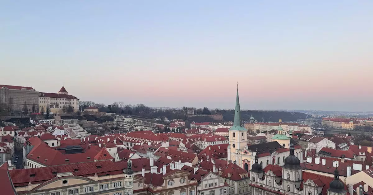 Aerial view of Prague Old Town with red roofs and church spire at twilight, Czech Republic.