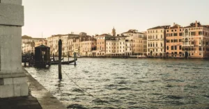 Discover the serene view of Venice's Grand Canal at sunset, showcasing historic architecture and tranquil waters.