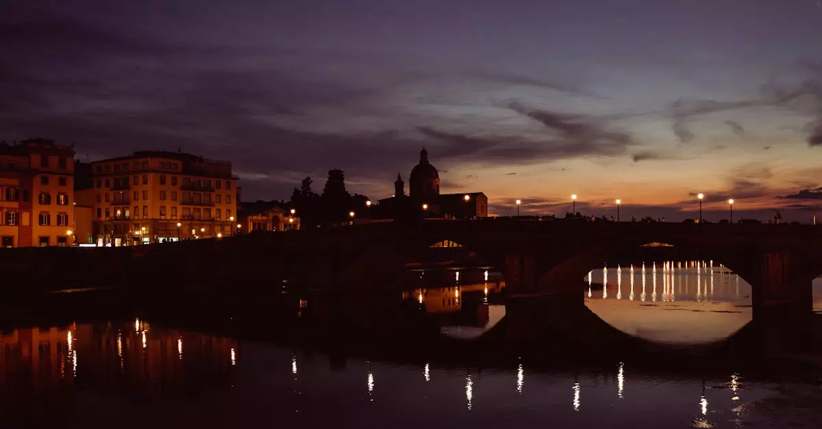 A picturesque view of Florence at twilight, showcasing reflections on the Arno River and historic architecture.
