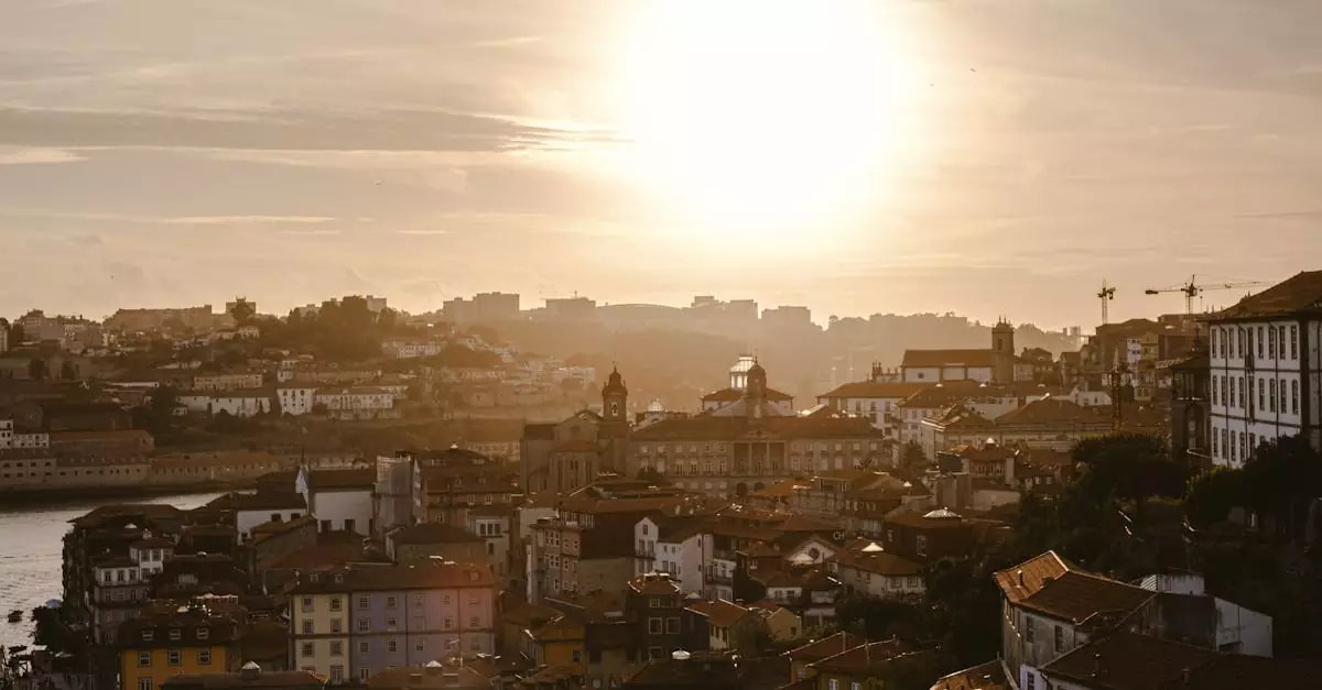 Golden sunset casting a warm glow over Porto, Portugal's historic cityscape with iconic architecture.