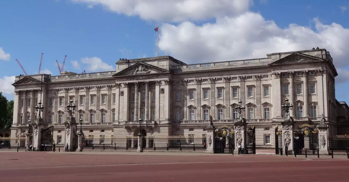A clear view of Buckingham Palace in London with blue sky and clouds in the background.