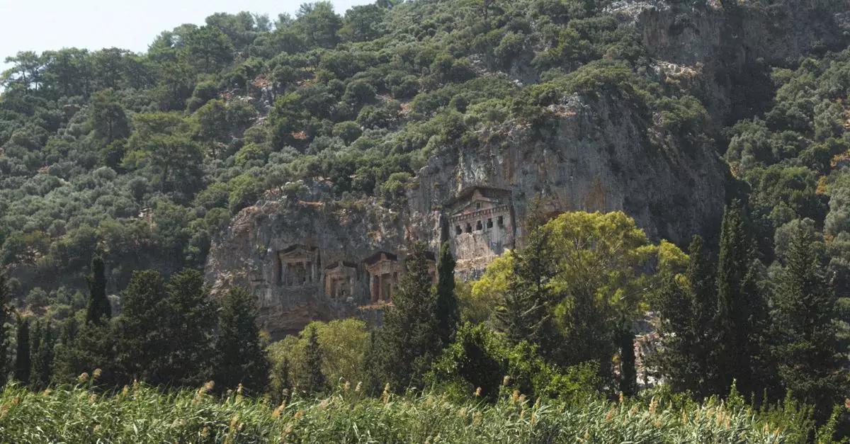 Scenic view of ancient Caunos tombs nestled in a verdant Turkish hillside.